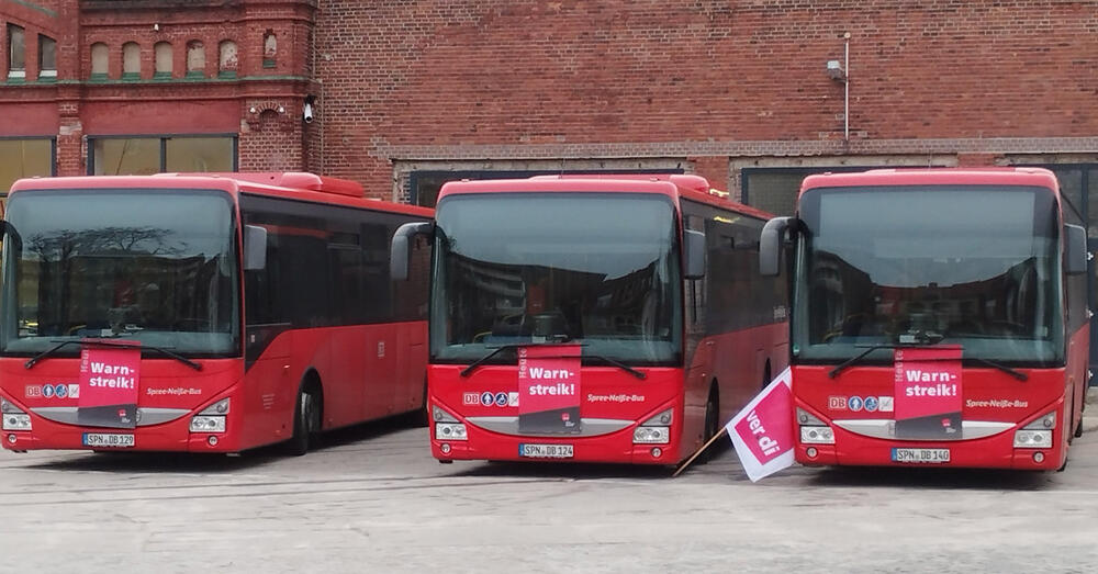 Drei Busse mit Warnstreik-Banner.